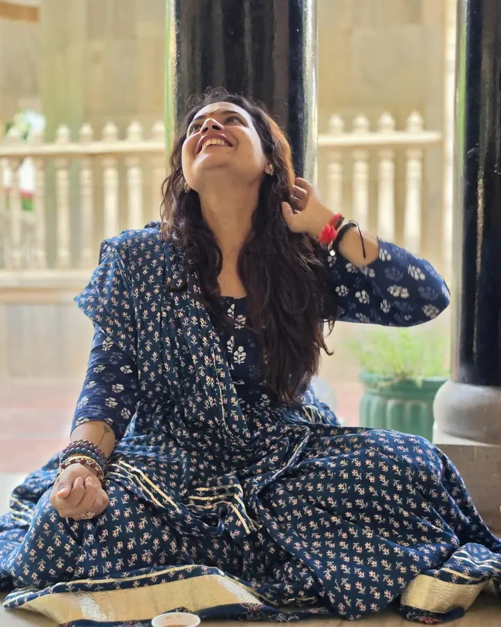 Dr. Sonali Mishra laughing, seated cross-legged